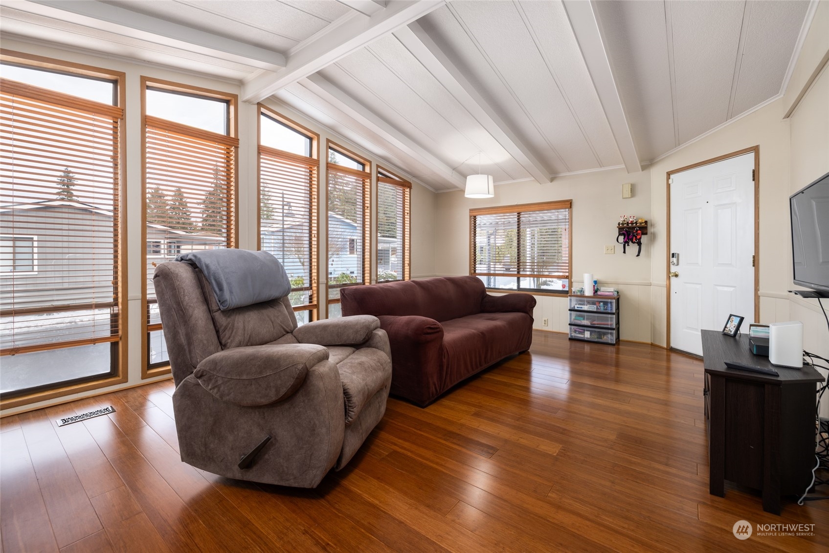 Floor-to-ceiling windows and vaulted ceilings create a spacious and light-filled living room