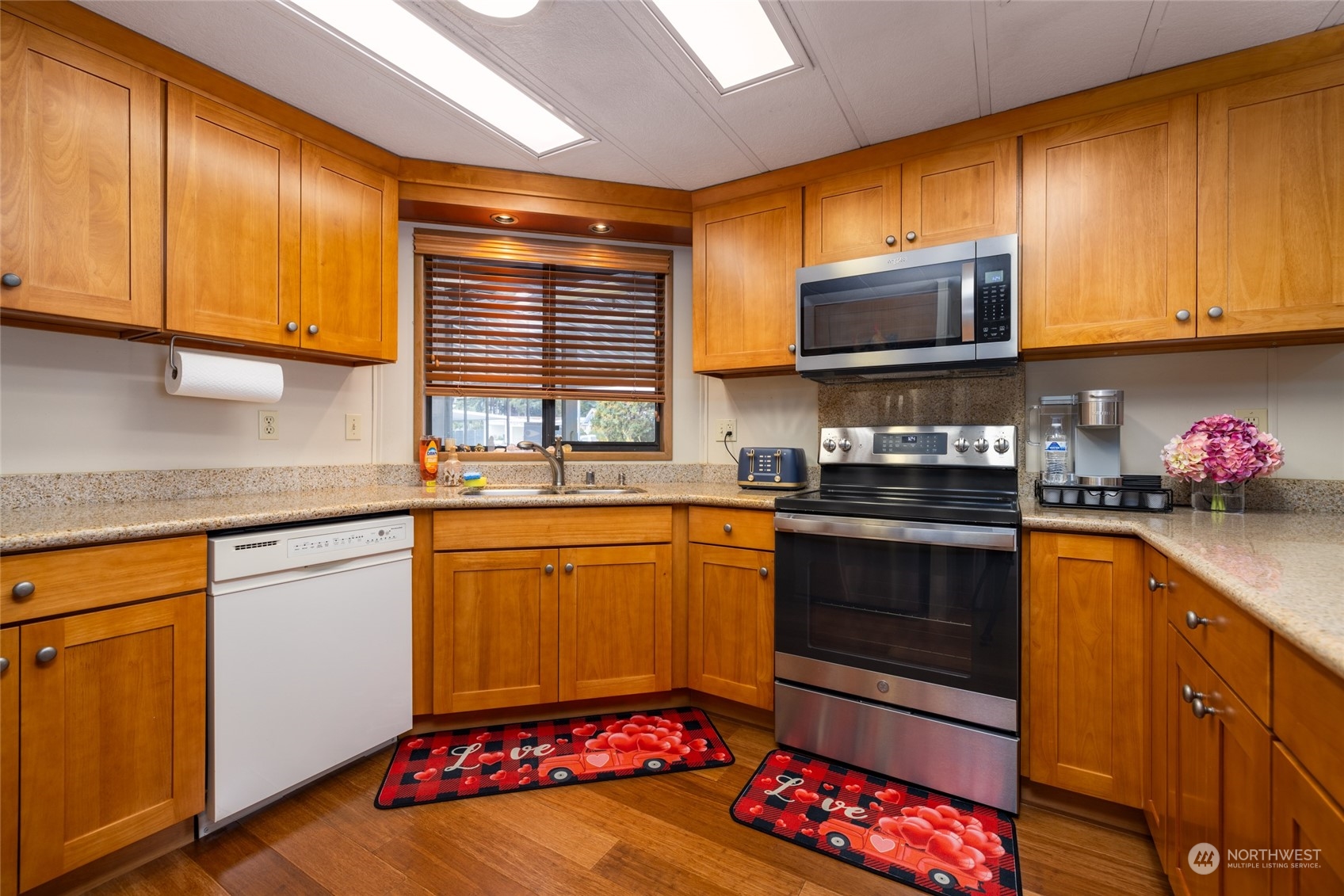 beautifully remodeled and functional kitchen features quartz counters and wood cabinets