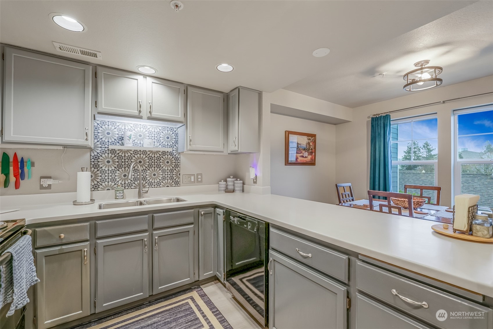 A different perspective of the kitchen showcases its efficient layout, with a spacious quartz countertop offering plenty of prep space. The modern stainless steel refrigerator and built-in microwave add to the contemporary feel, while the painted cabinets provide ample storage. This kitchen is both stylish and practical, making cooking a pleasure.