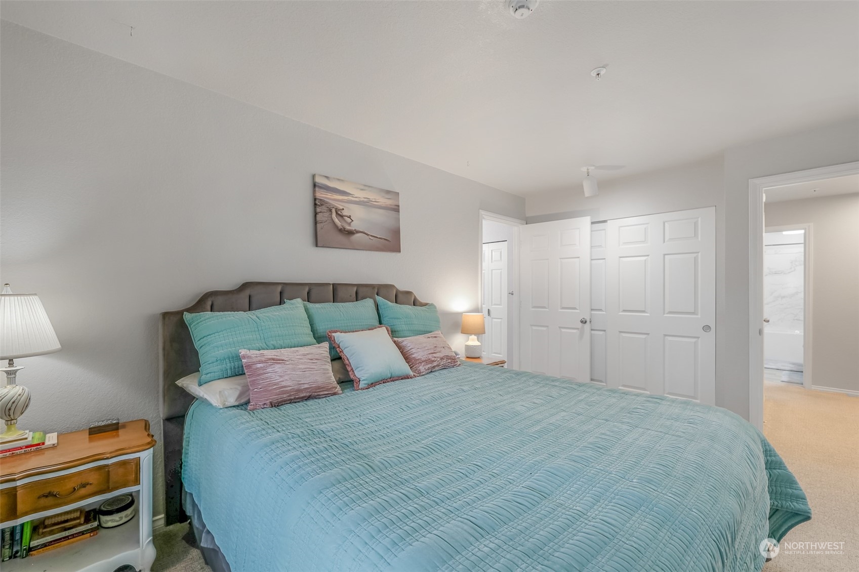 This angle highlights the room’s ample space and thoughtful design, including 2 large closets for storage. The open doorway leads to the beautifully updated en-suite bathroom, ensuring privacy and convenience.