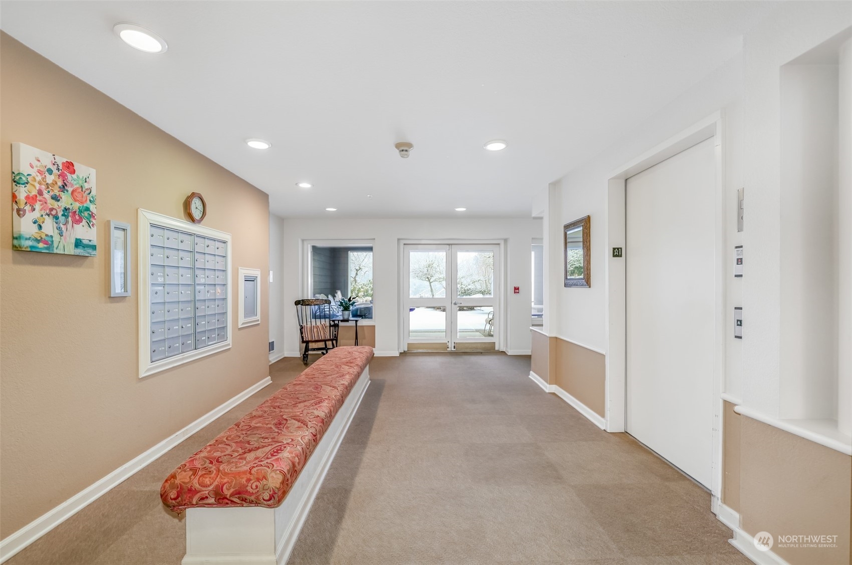 A mailroom and common area featuring individual mailboxes, elevator access, and a bright, open layout, providing a welcoming entrance to the building.