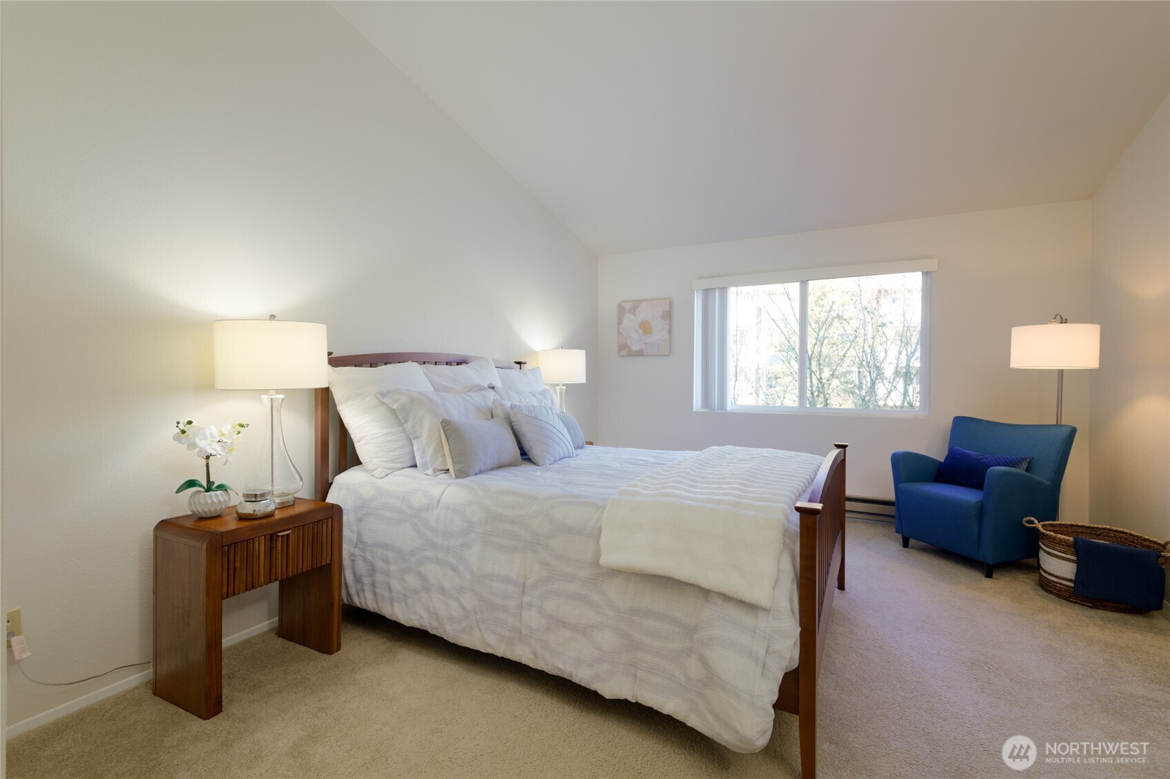 The spacious primary suite is a bright and airy retreat, filled with natural light streaming through large windows. Vaulted ceilings add to the sense of openness, creating a relaxing and luxurious atmosphere.