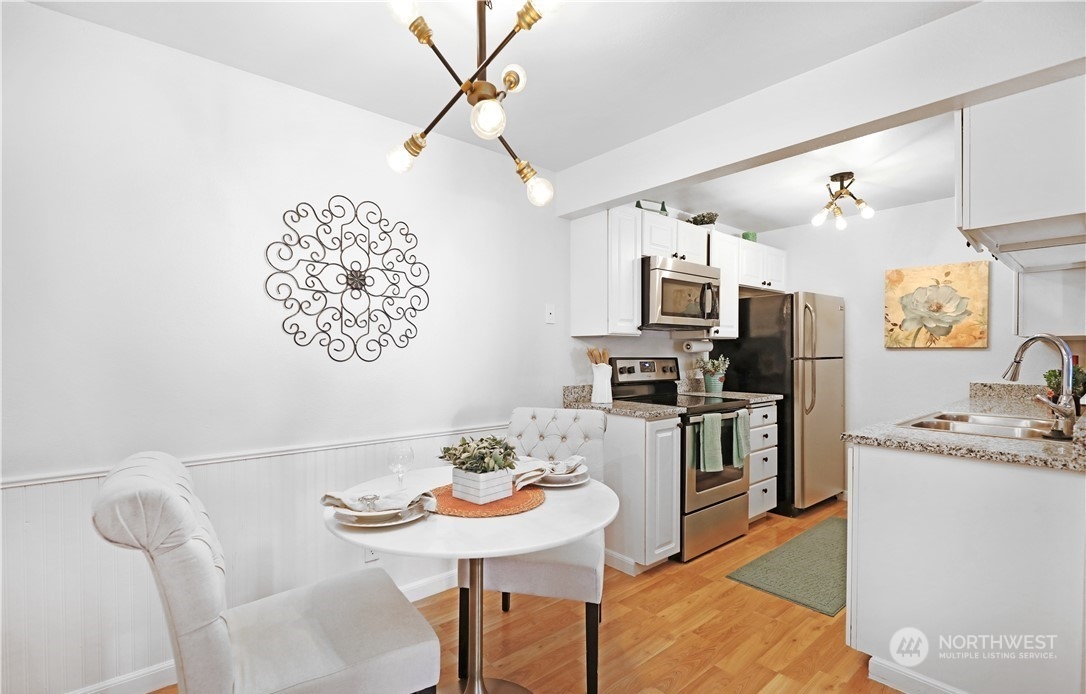 Dining/kitchen. Photo includes staging, unit currently vacant.