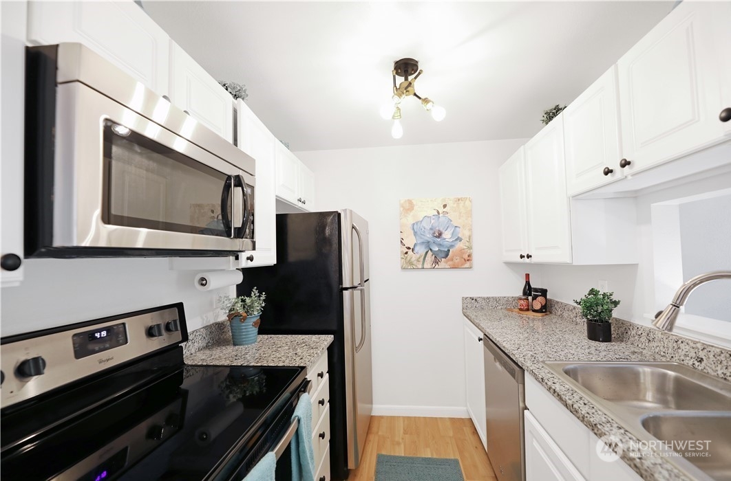 Kitchen. Photo includes staging, unit currently vacant.