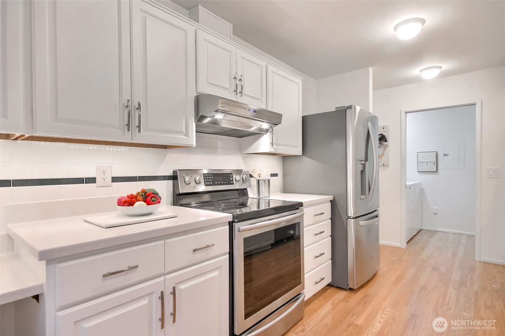 Updated kitchen with new SS appliances, white cabinets with pull-outs, and updated counters. Enjoy the extended cabinets and desk area and nook.