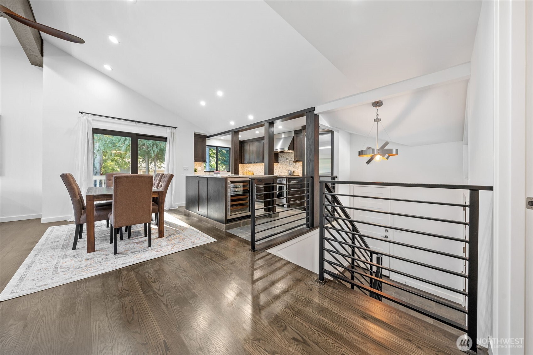 Once you walk up, you’re welcomed by a bright and airy open-concept space with solid oak hardwood floors, soaring vaulted ceilings. The modern kitchen and dining area blend seamlessly, offering a perfect setting for gatherings.