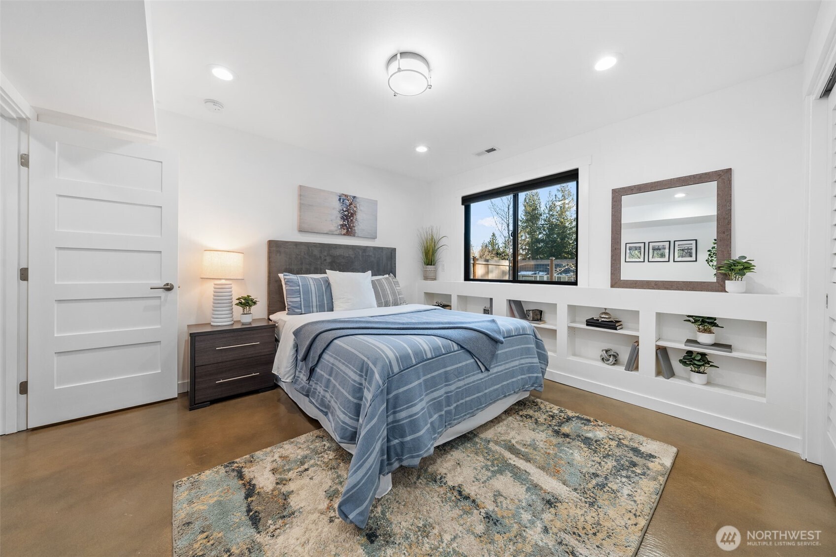 Bedroom 2 offers a peaceful retreat with a stylish design and serene ambiance. Notice the built-in shelves and the custom Elfa® Closet System, adding both functionality and elegance to the space.