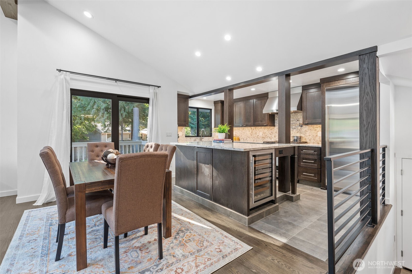 Guests can gather around the island while meals are prepared, and the flawless transition to the dining space makes hosting effortless. Notice the secret storage cabinet built into the island—take a look at it while you are viewing this home!