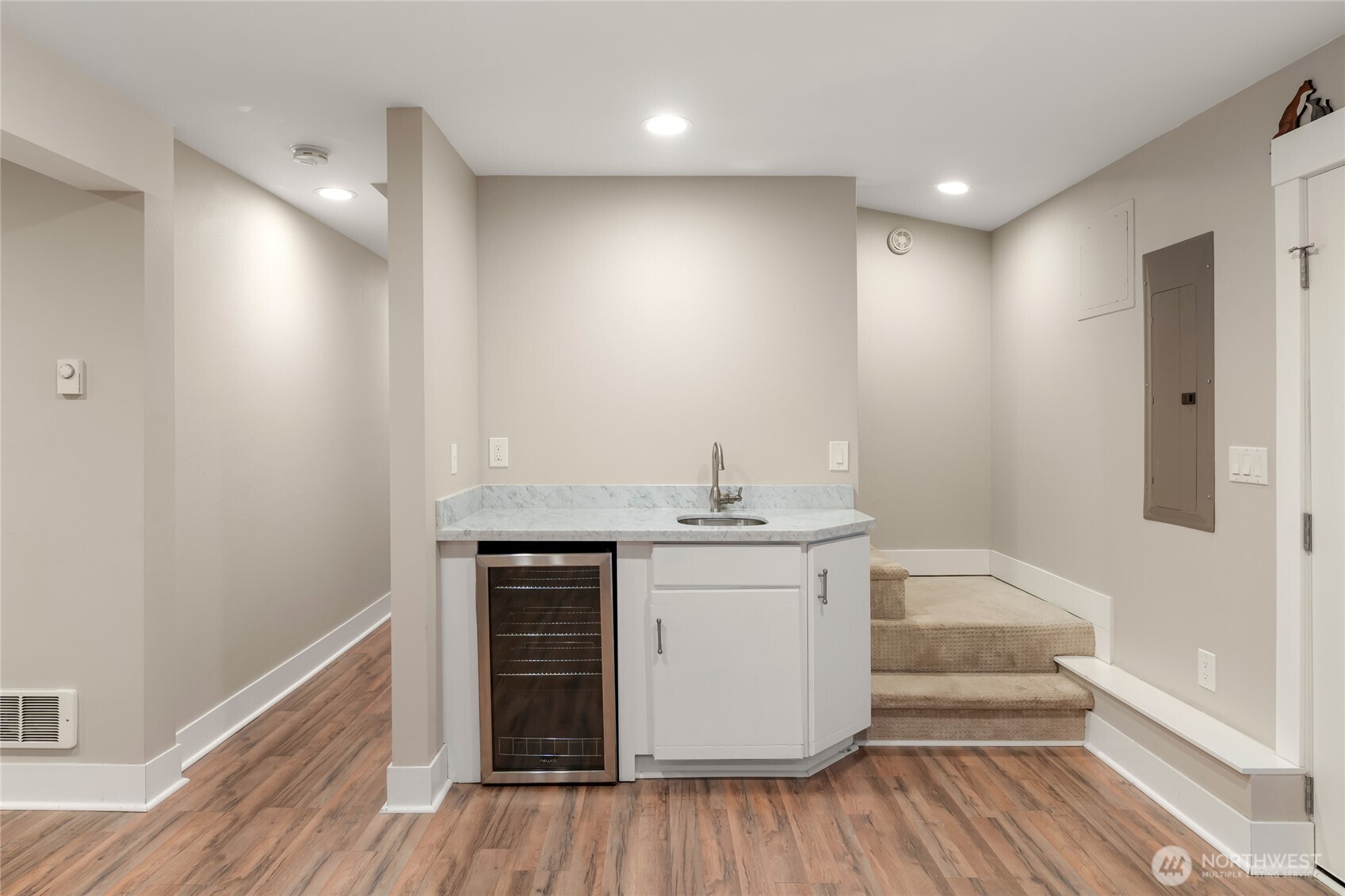 Wet bar with marble counter and fridge.