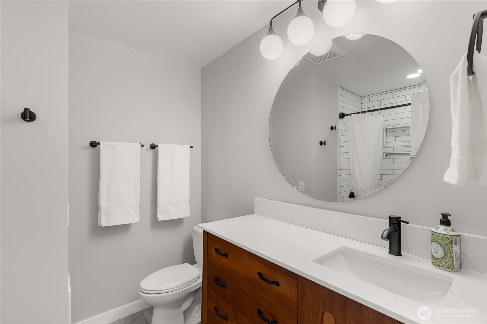 Custom quartz counter tops mid-century dresser in main-floor bathroom.