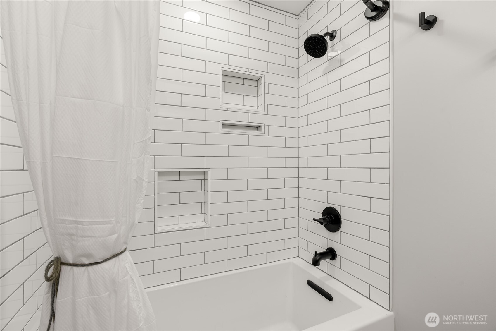 Custom tiling surrounds a tub designed for luxurious soaking.