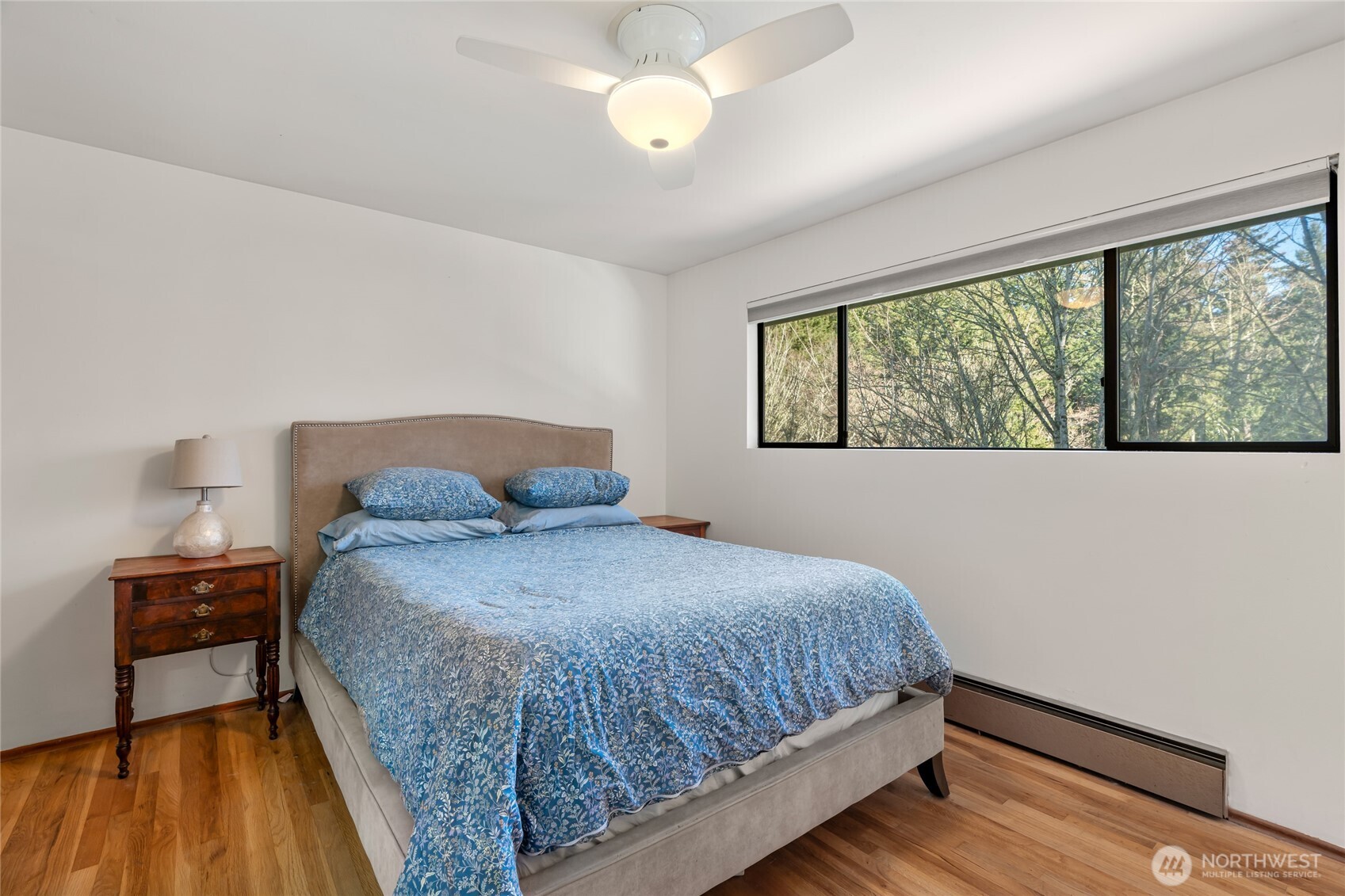 Primary bedroom with high windows to add a sense of tranquility and privacy, and blackout blinds for sleeping in.