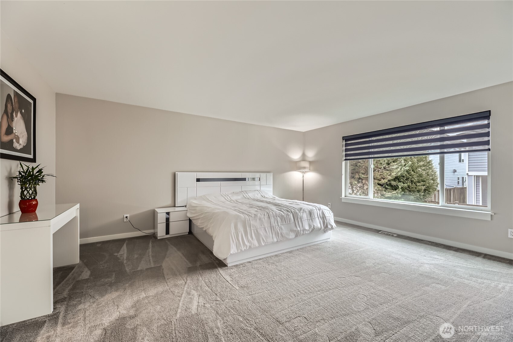 Oversized primary bedroom with a large window and room for a sitting area.