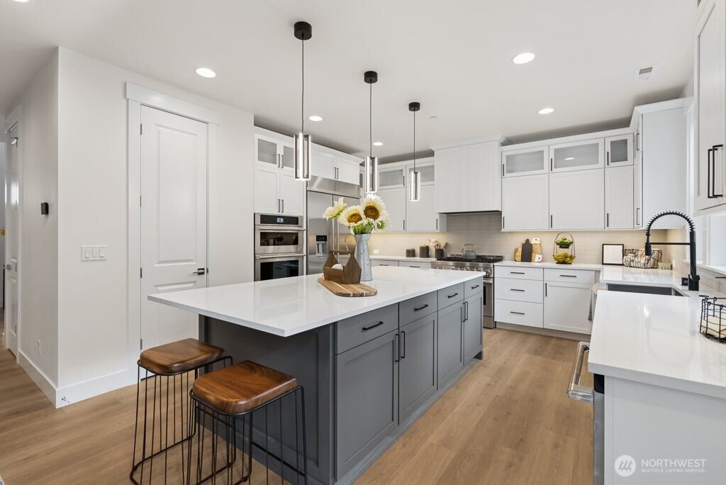Chef's kitchen with quartz counters, soft close Huntwood cabinets, walk in pantry, beverage fridge, and full height backsplash.