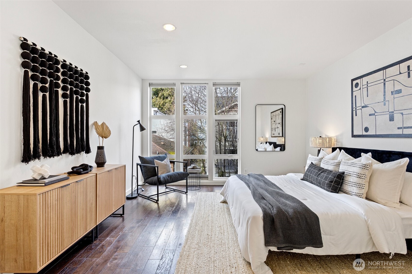 View primary bedroom with large floor to ceiling, north-facing windows.