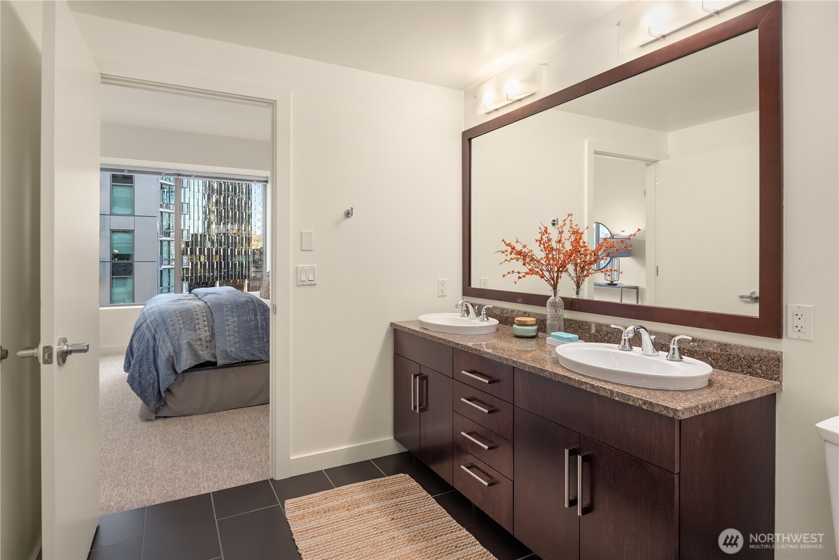 This spacious bath features a double vanity, extensive tile work and a large tiled shower.