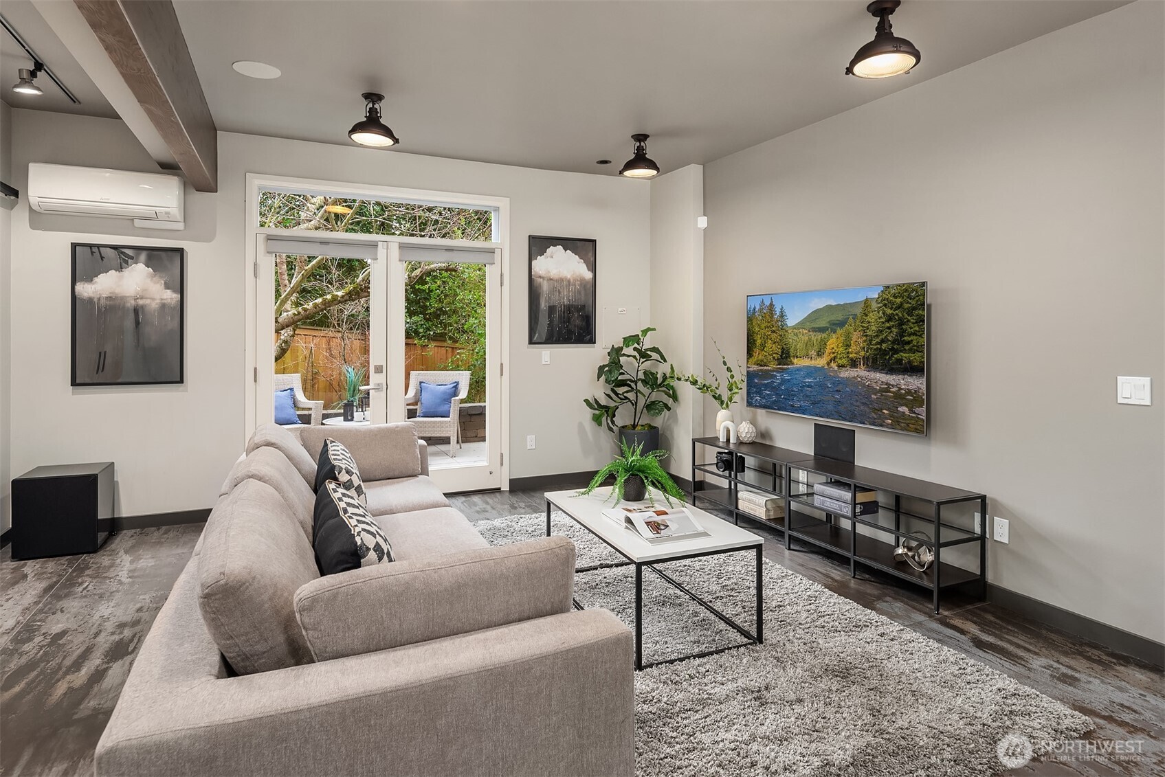 Contemporary family room showcases French doors to private patio, industrial lighting, and elegant architectural details.