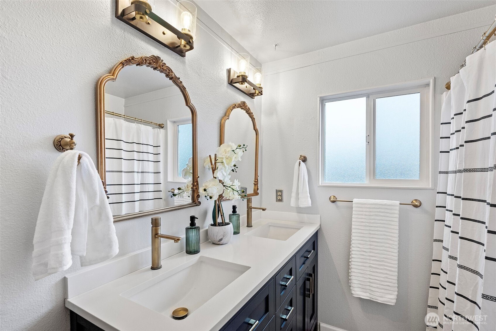 The full bathroom off the hall has a beautiful, new blue double vanity and lux finishes.