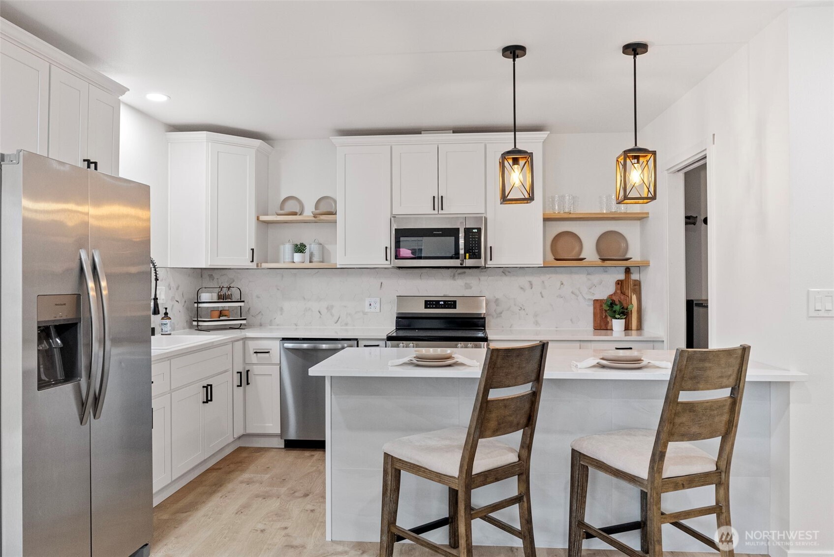 This kitchen feels HUGE in person. Quartz countertops, stainless steel appliances, and SO much storage.