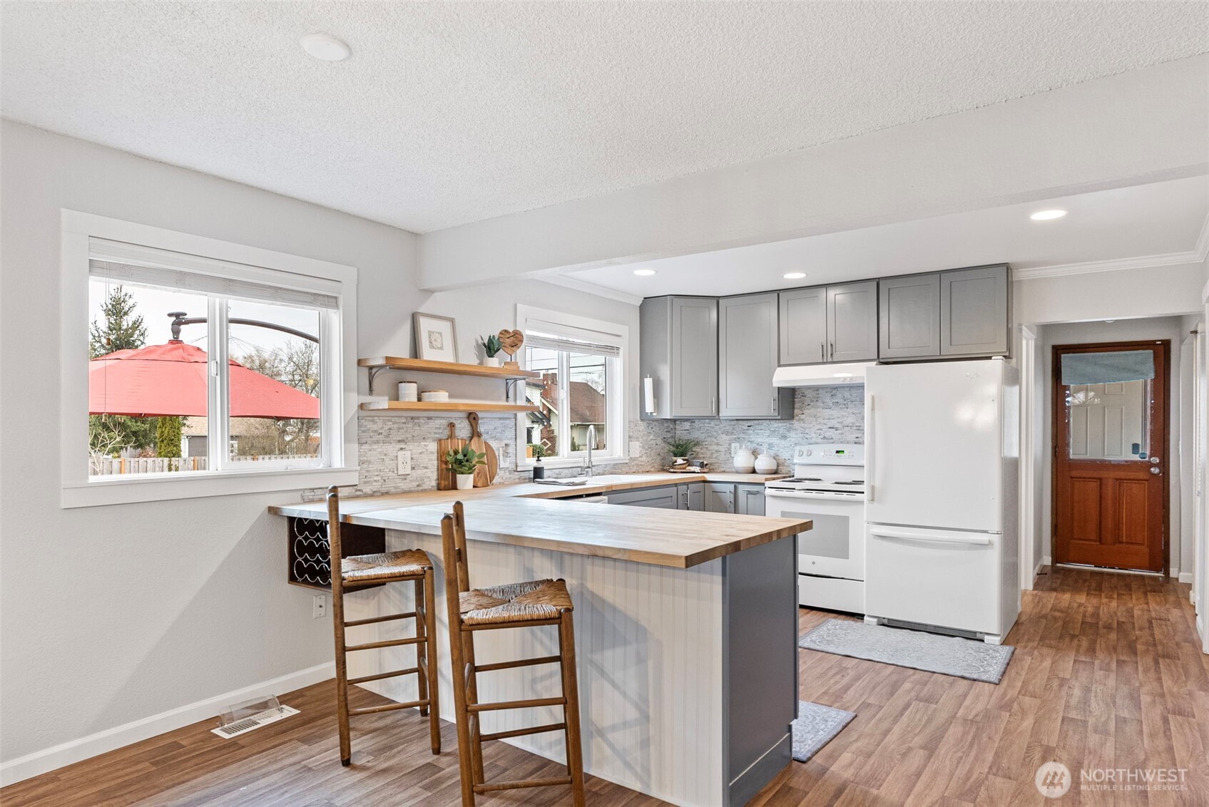 The newly remodeled kitchen features butcher block countertops, open shelving, and plenty of storage!