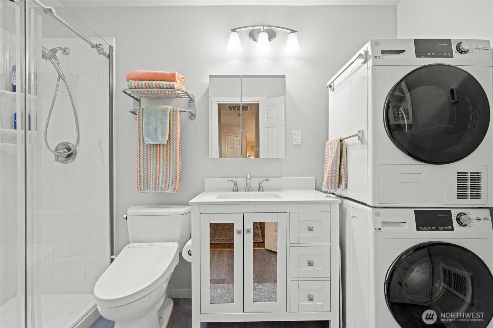 The hallway bathroom has been updated: the bathtub was removed so now you have a step-in shower with hanging glass doors. Also new is the comfort height toilet with remote controlled bidet, plus a stacking washing machine with a ventless dryer.