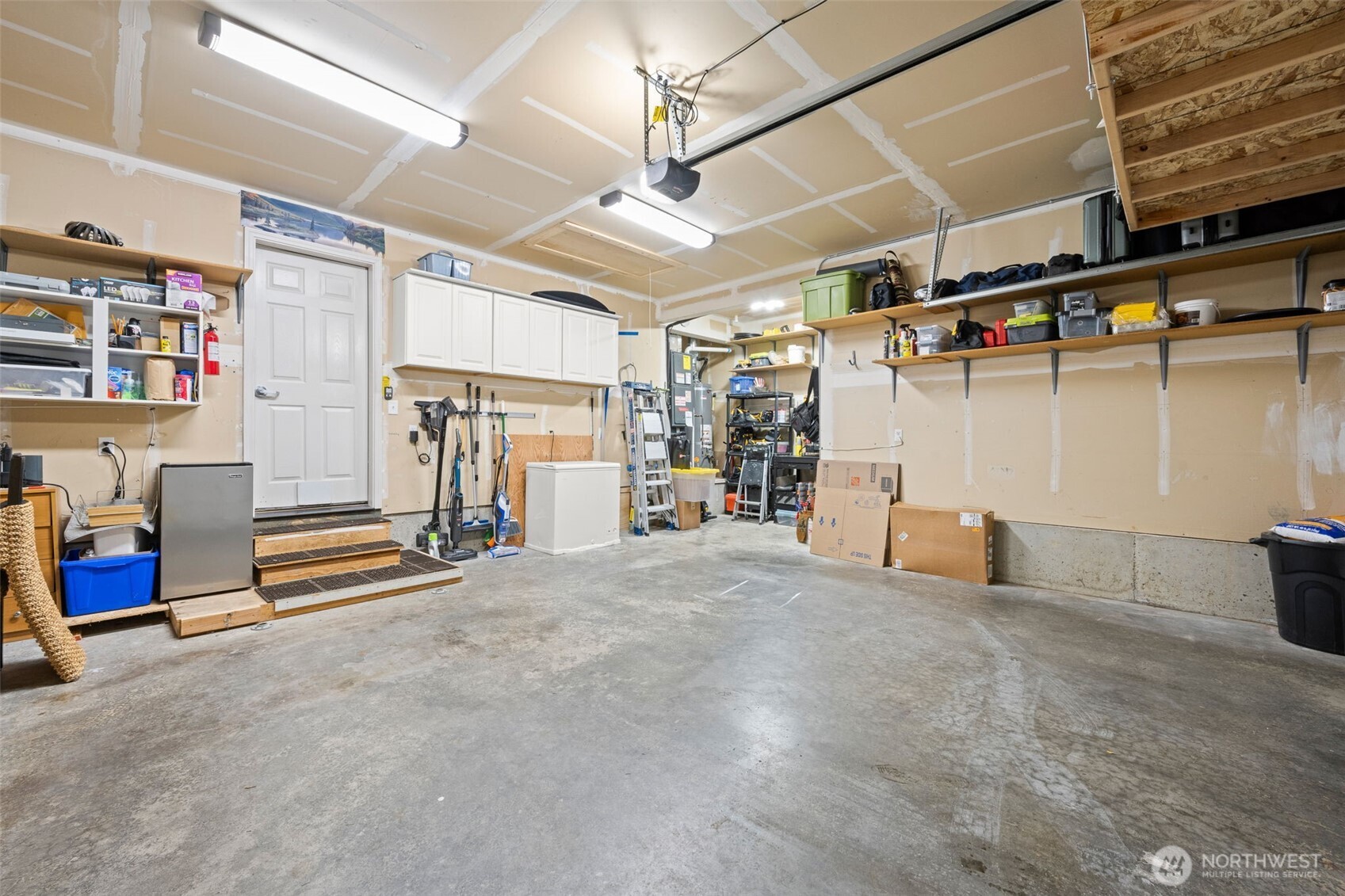 The garage features a generous workshop area, storage cabinets and lots of light.