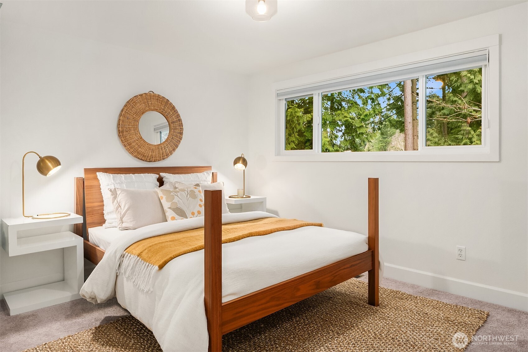 The roomy primary bedroom features a distinguished accent wall, soothing interiors and a wealth of natural light with serene views of the tree-laden yard.