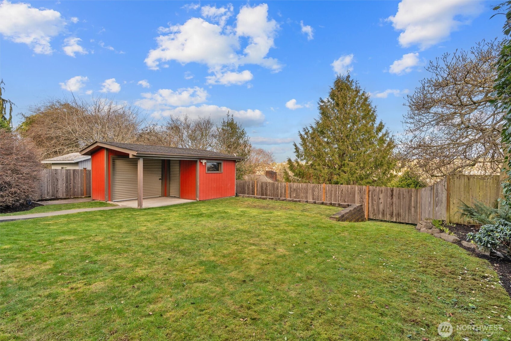 Expansive backyard complete with a modern shed that provides more storage