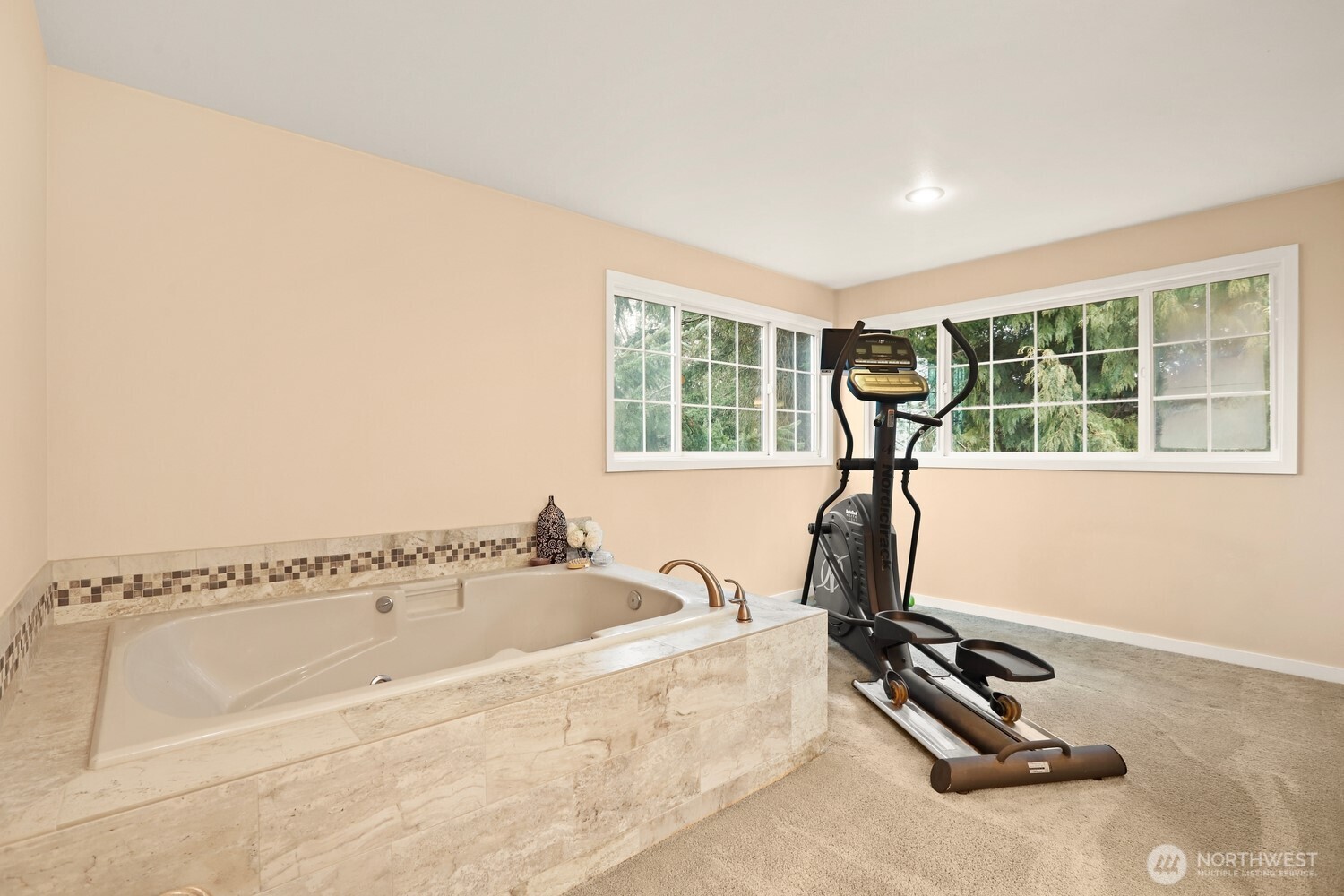 Large en suite bathroom with jetted tub and workout area.