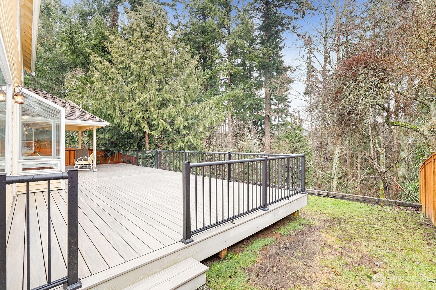 New composite deck perched above forest with seasonal stream.