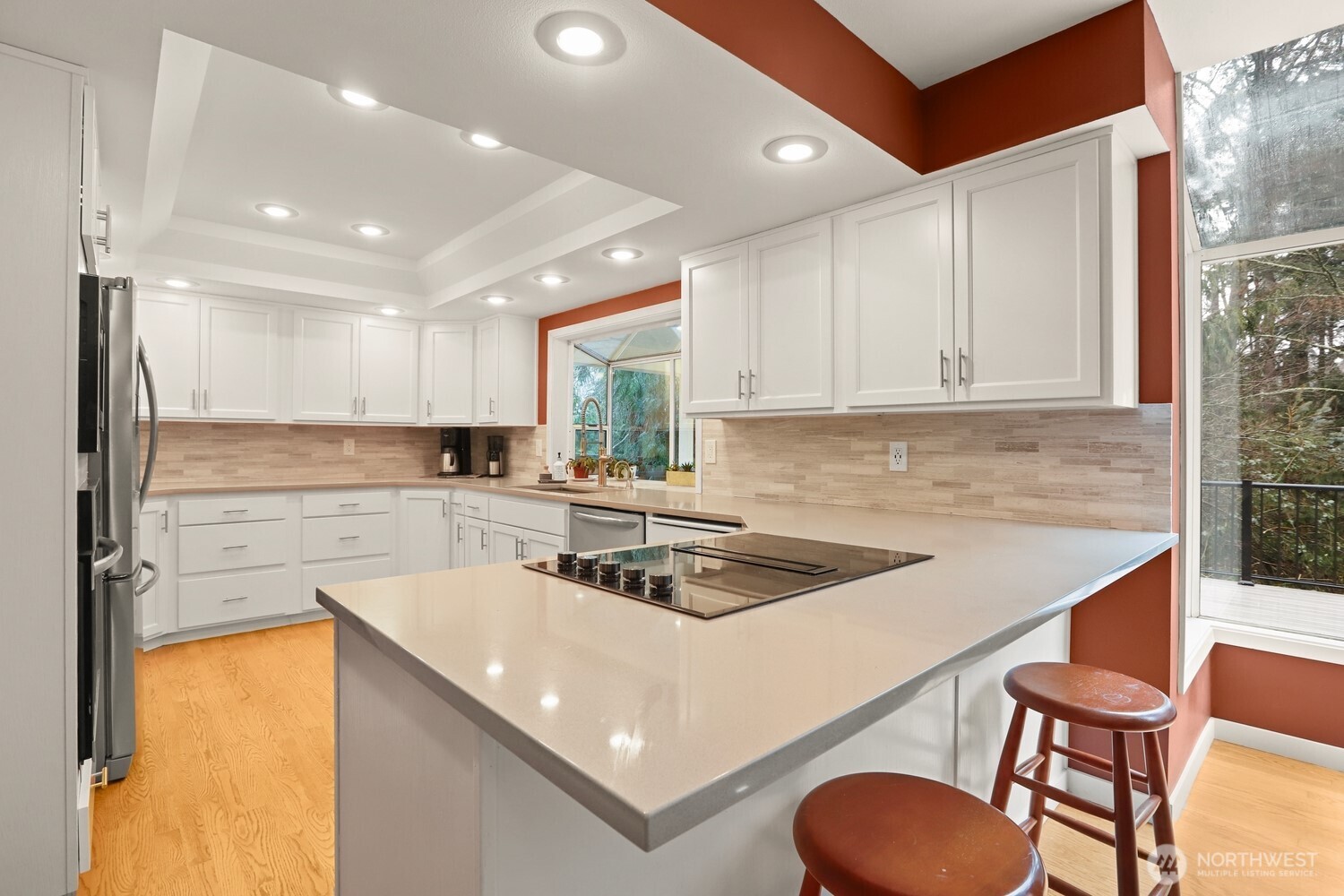 Newly updated kitchen with quartz counters, tile backsplash, and stainless appliances.