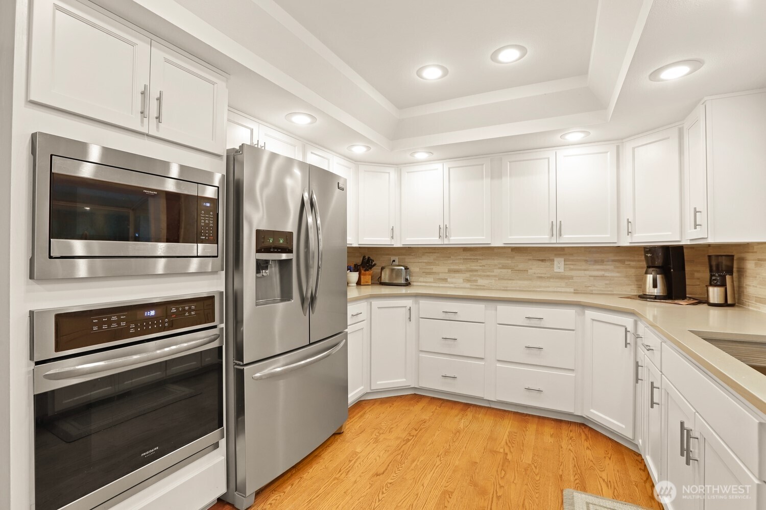 Newly updated kitchen with quartz counters, tile backsplash, and stainless appliances.