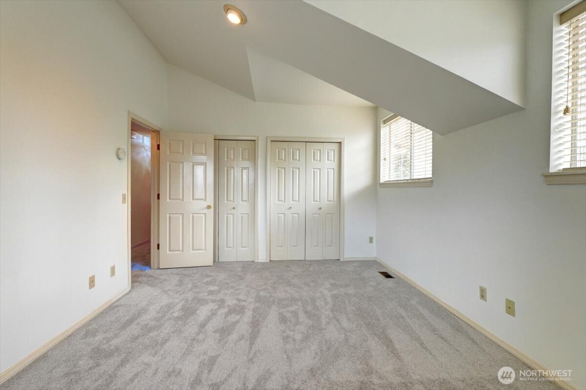 Opposite view showing double wardrobe closets and vaulted ceilings.