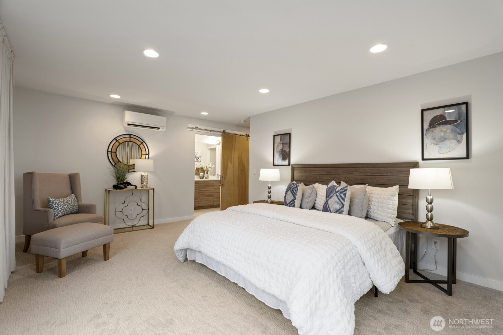 Another view of the primary bedroom, including barn door entrance to the private bath.