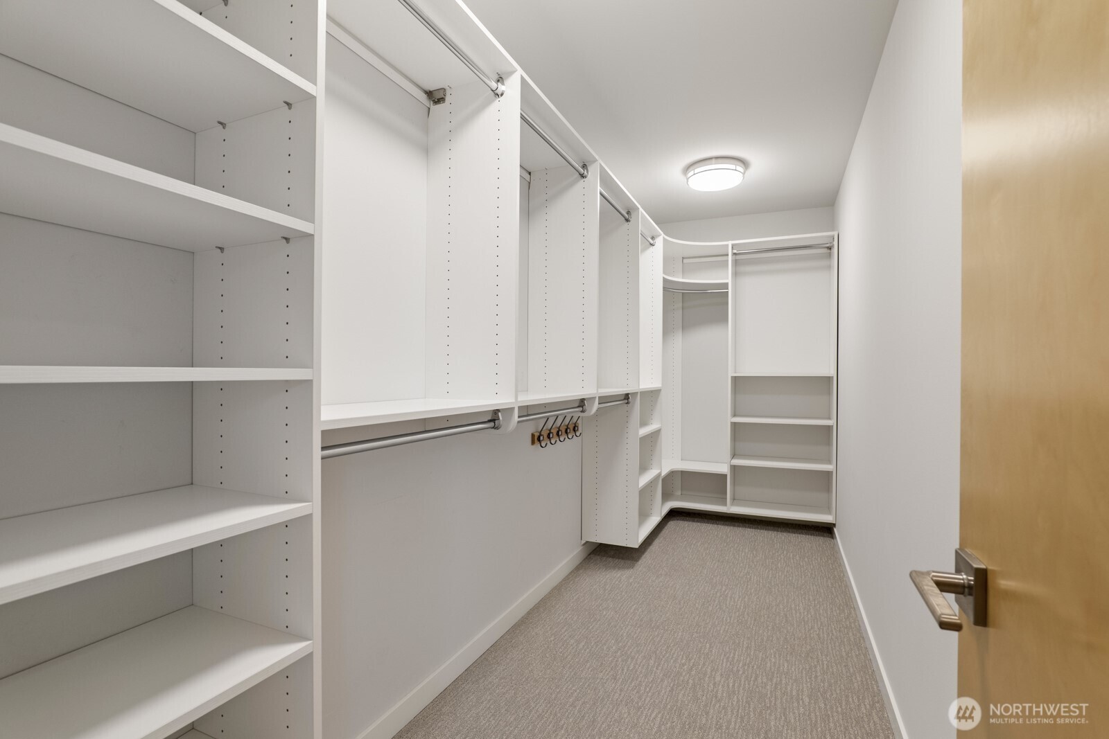 Primary suite walk-in closet with custom built-in organizers.