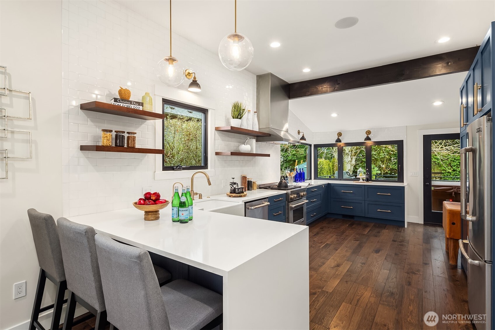 You've got to love a crisp, clean kitchen with gorgeous wood elements that all tie together ... floating wood shelves, rustic wood beam and scrumptious wood floors. A definite WOW factor!