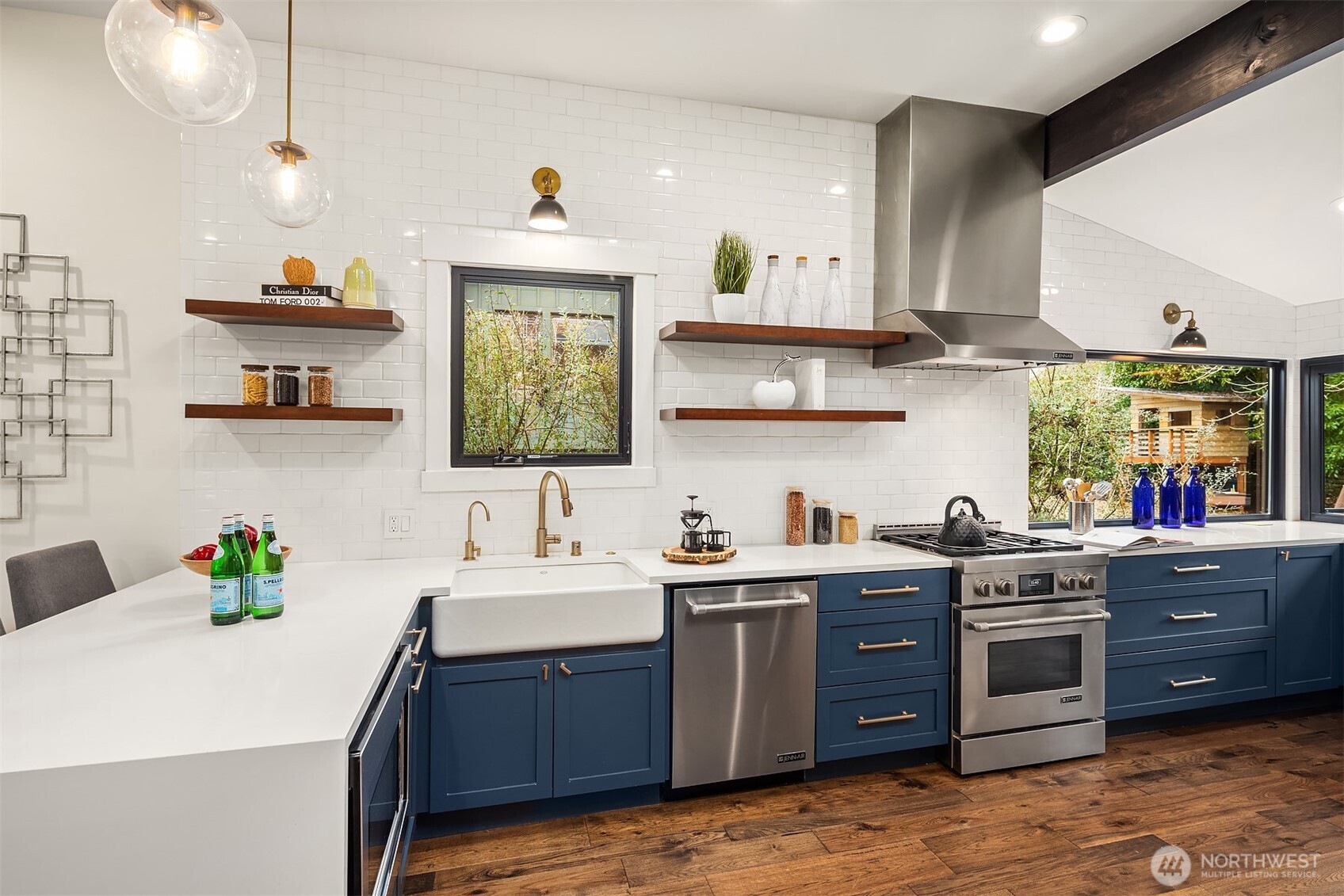 A epicurean's dream kitchen! 6 burner Jenn air gas stove with powerful overhead hood, Jenn air stainless dishwasher, a farm style sink with champaign bronze faucet and a matching hot water dispenser.