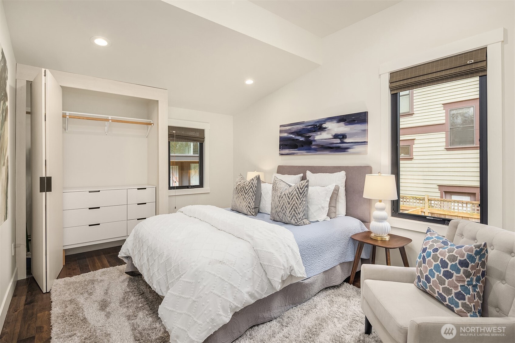 Another view of primary bedroom showcasing the custom built-in closet system.