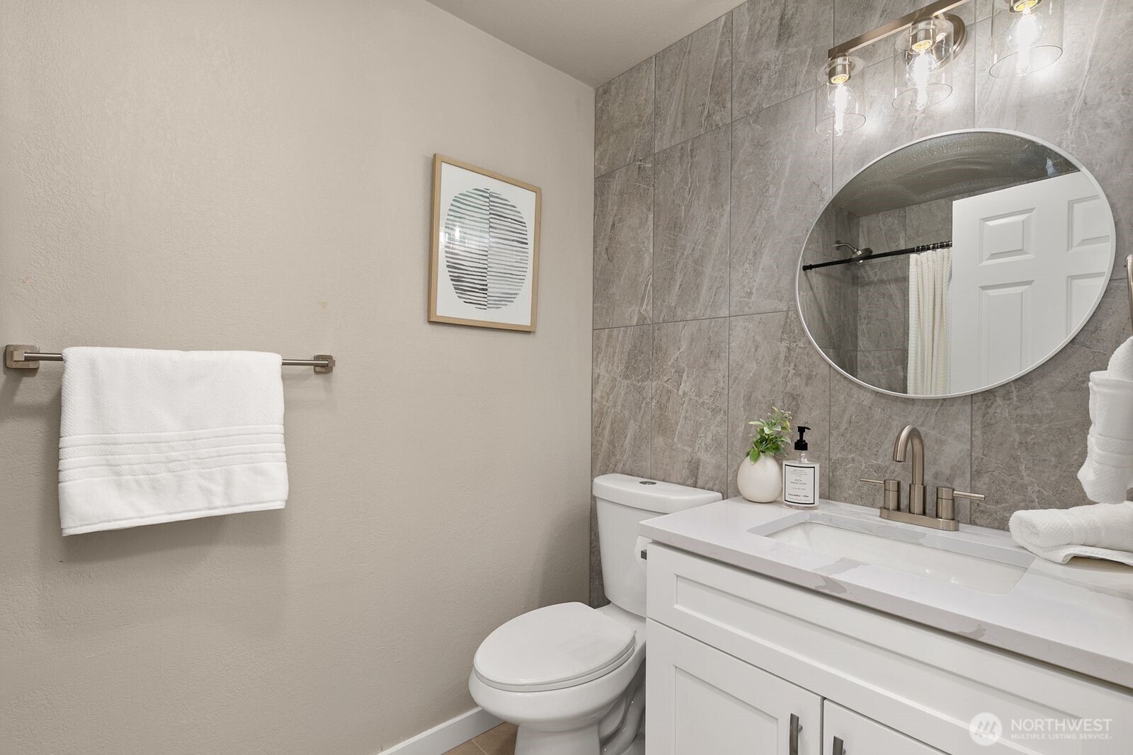 Refreshed bathroom with tile on shower and vanity wall