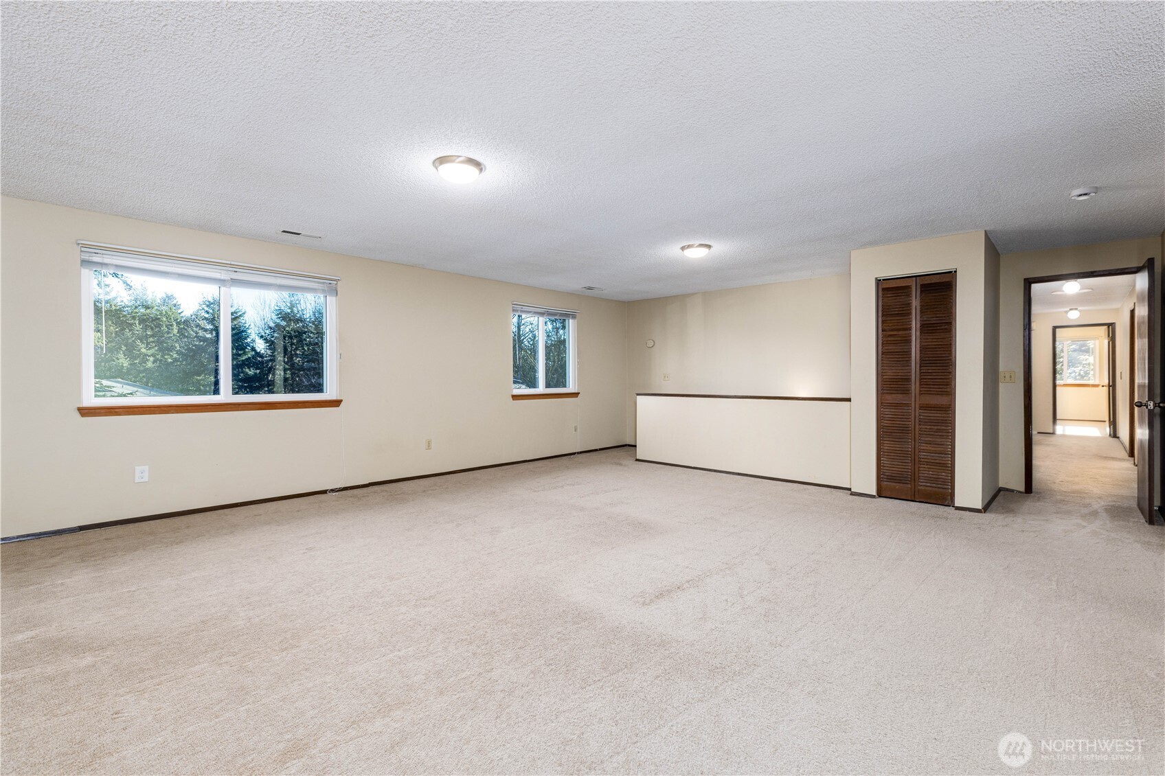 Another view of the bonus room with hallway to bedrooms.