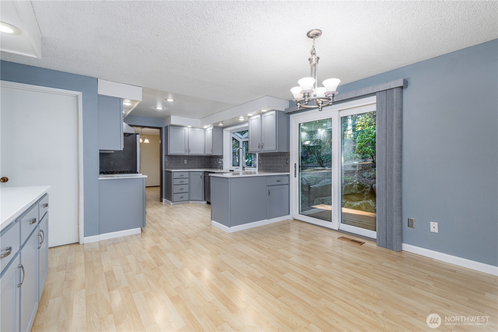 Welcoming eat-in kitchen with dining area and sliding doors that open to the backyard.