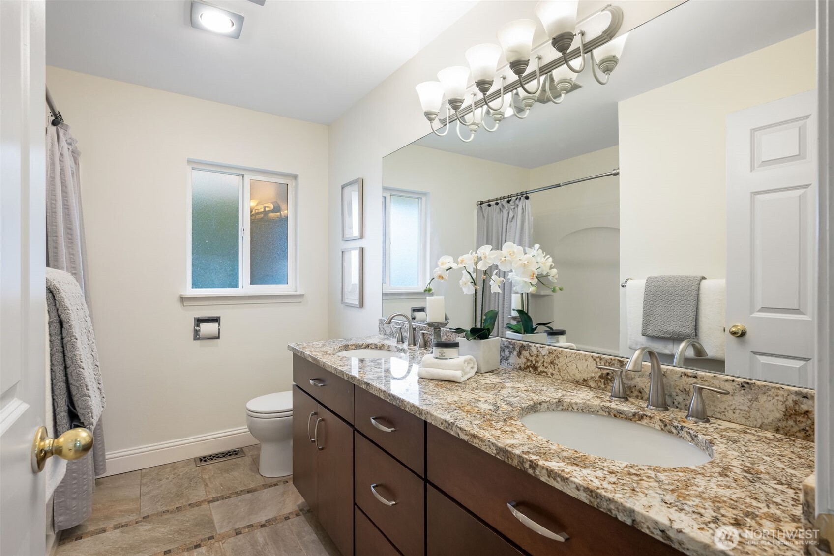 The bathroom has been renovated, and features double vanity sinks.