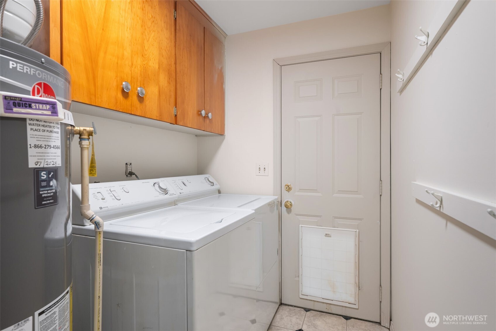 Laundry room with a new hot water tank and a dog door that leads out to the backyard.