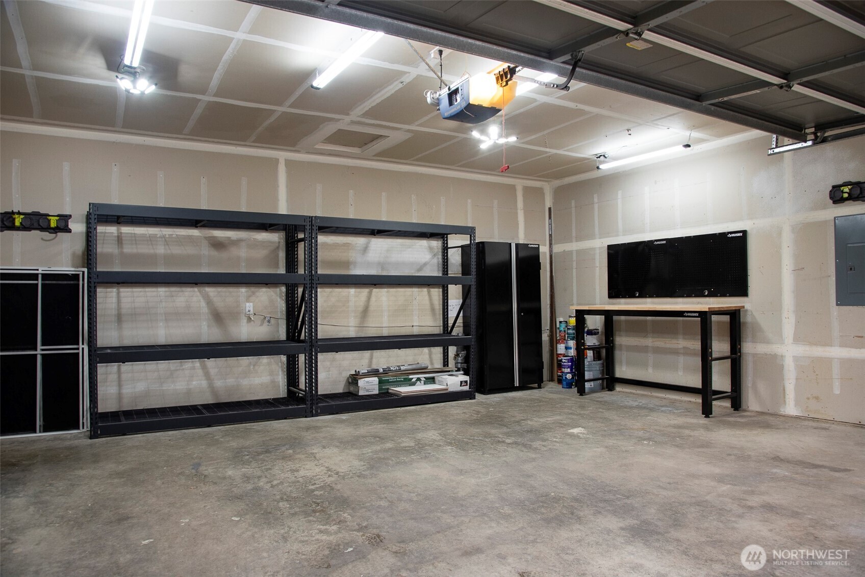 Spacious 2 car garage comes with workbench, locked storage cabinets and shelving. Outlets in garage allow EV charging.