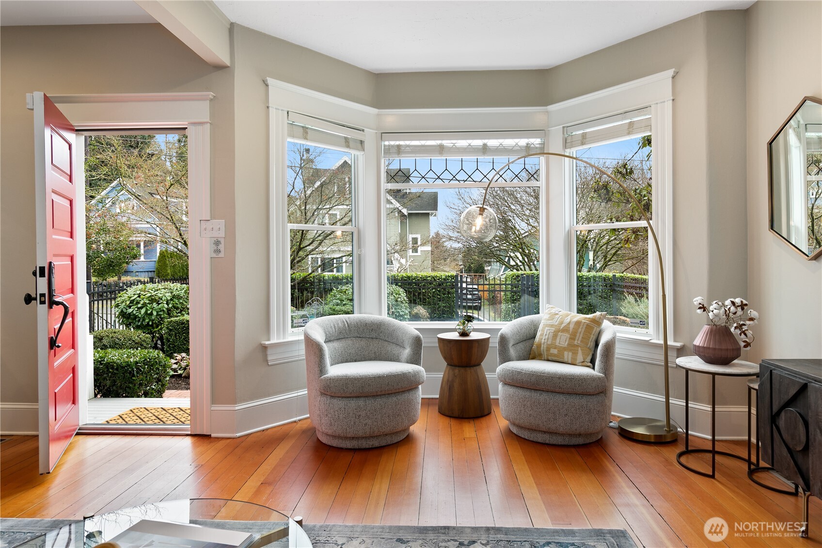 The inviting bay window with intricate leaded glass details offers a picturesque view of the beautifully manicured front patio as well as the street below.