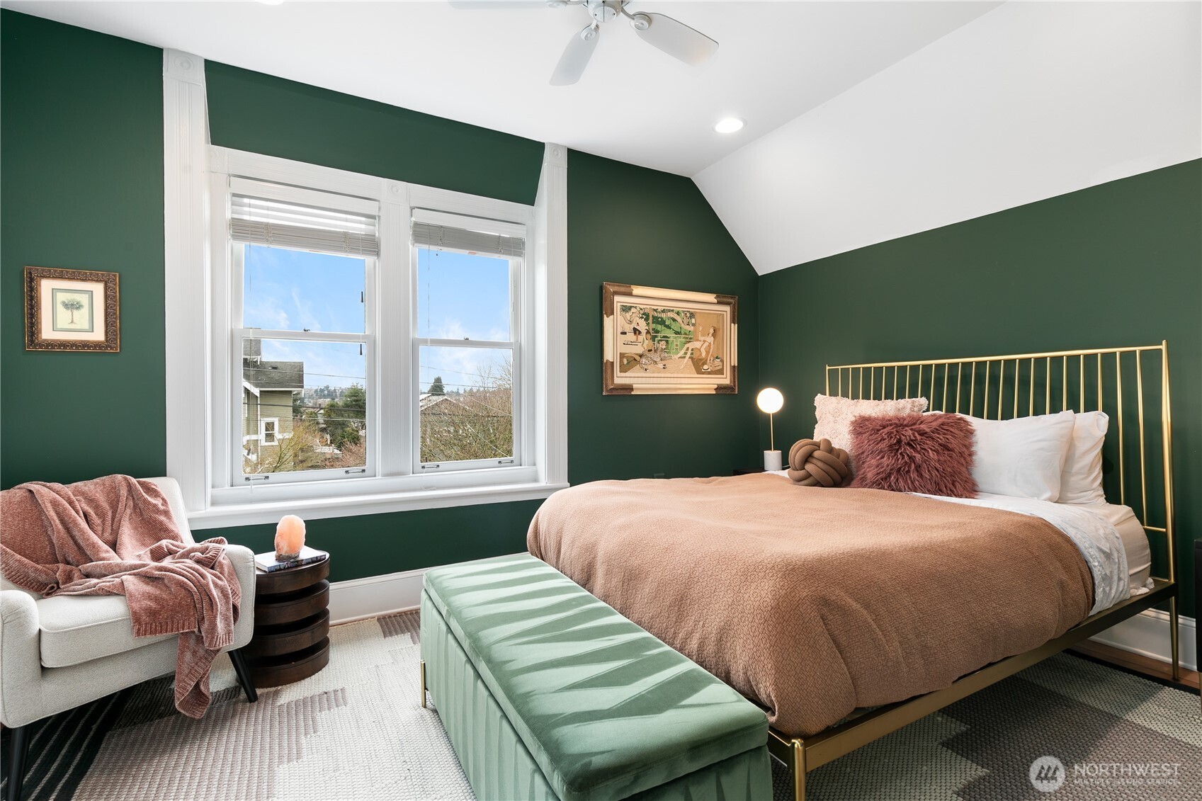 Modern meets serene in this bedroom, painted in a deep green hue that exudes sophistication. The spacious layout is complemented by large window that provides peek-a-boo views of Green Lake.