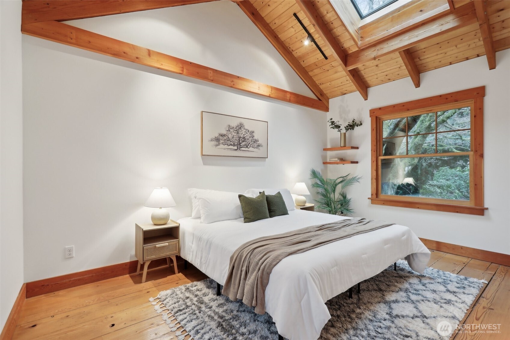 Primary bedroom boasts a skylight on the vaulted ceiling.