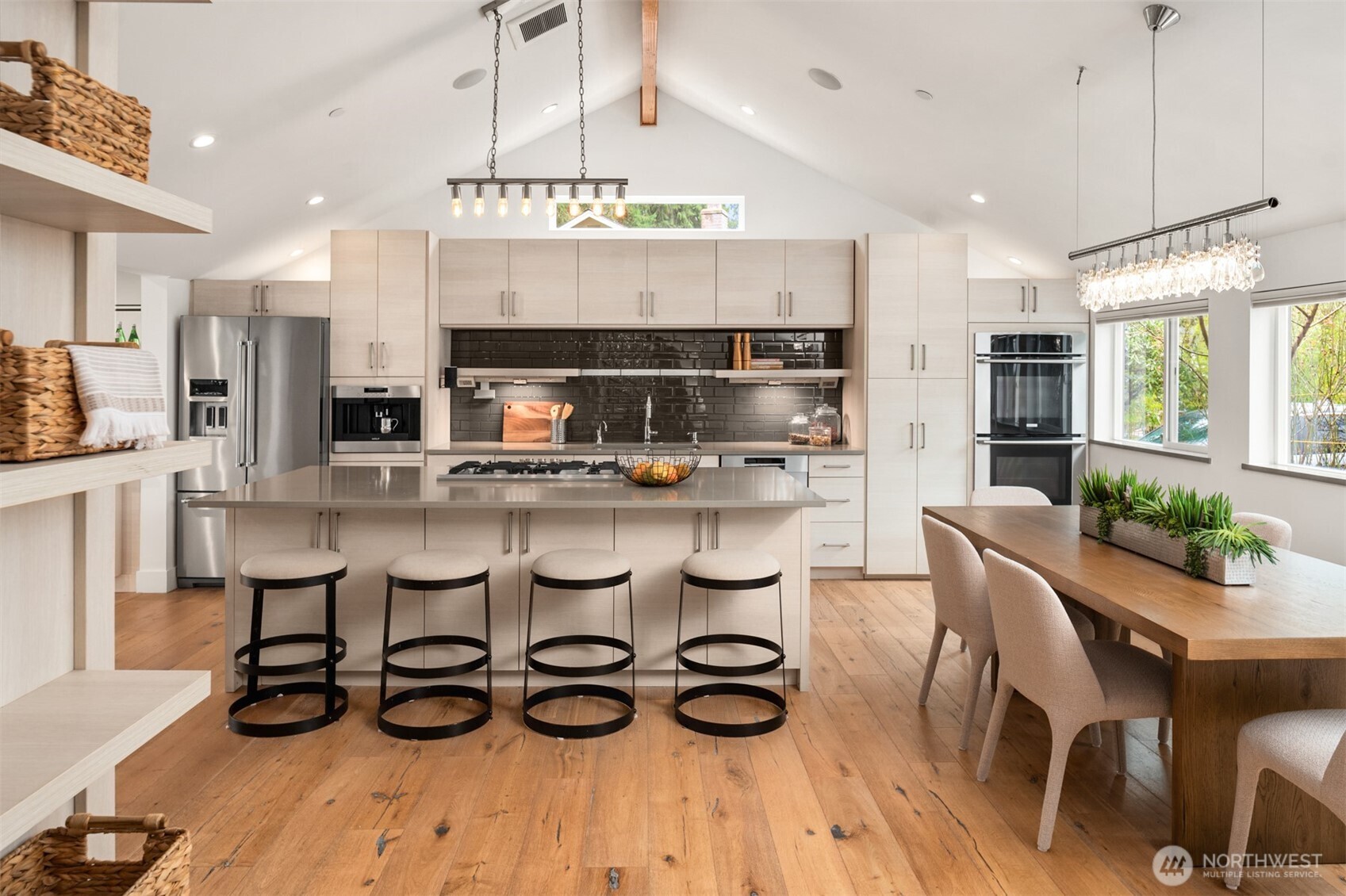 The kitchen in the heart of the home with a gorgeous oversized island and vaulted ceilings creating an inviting space for gatherings.