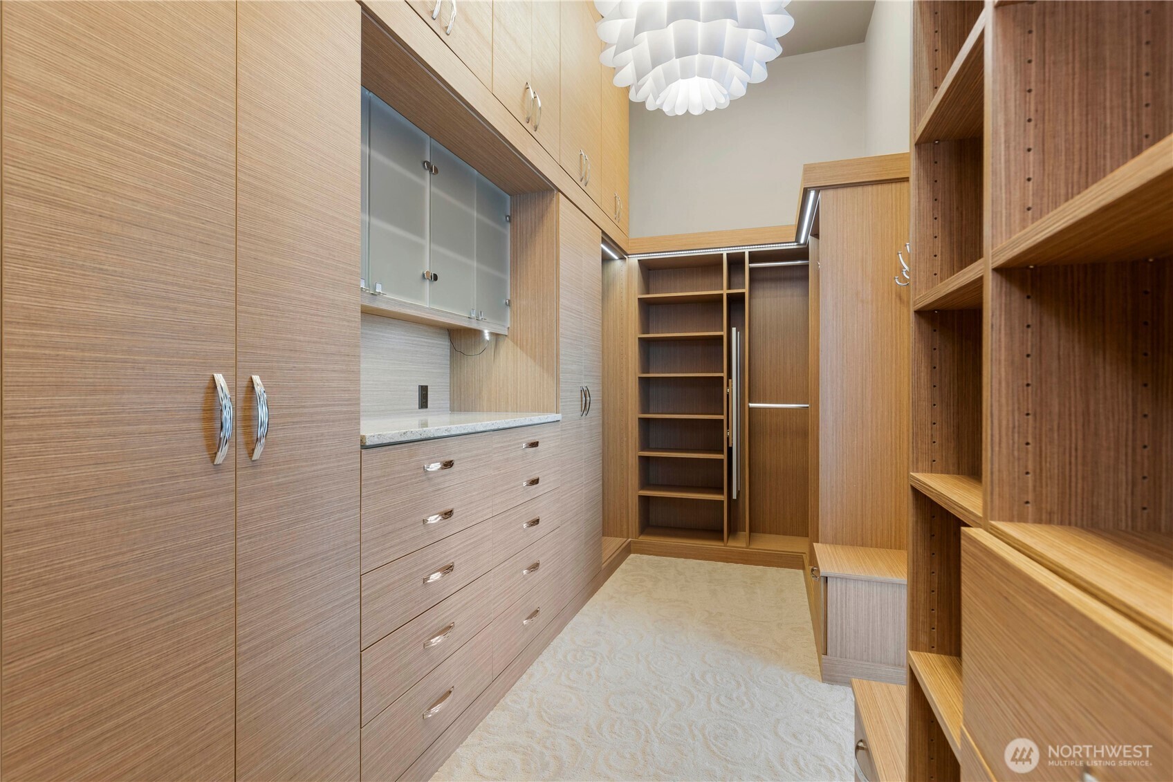 Primary closet with lots of shelving and cupboards