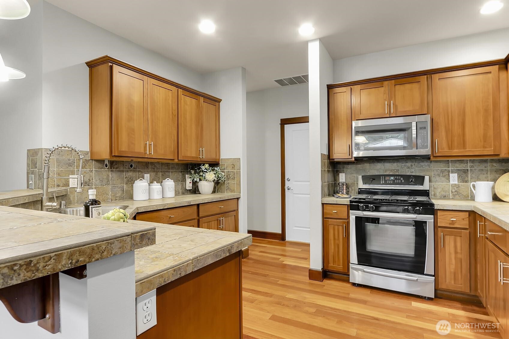 Kitchen features stainless steel appliances and ample counter space.